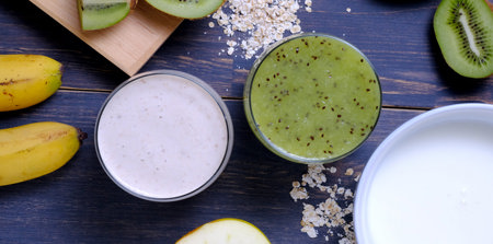 Zwei Gläser, eines gefüllt mit Bananenmilch und das andere mit einem Kiwi Smoothie.