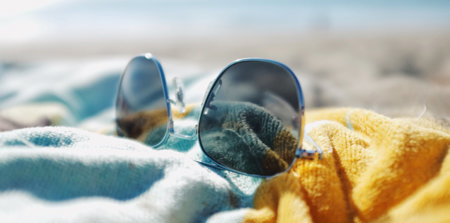 Eine Sonnenbrille auf einem Tuch liegend.