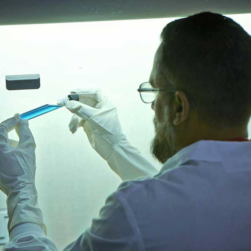 Scientist holding a blue vial in the lab
